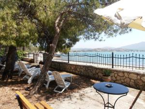 a patio with chairs and a table and a view of the water at Ormos Drepanou Apartments in Lygia