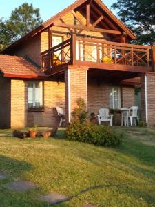 a house with a deck on top of it at Cabañas Dalga Inn in Merlo