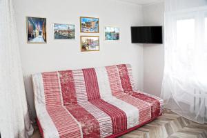 カリーニングラードにあるApartaments on Sergeeva 61のソファー付きの客室で、縞模様の毛布が備わります。