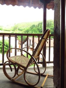 Zubieta的住宿－Albergue Olasenea Aterpea，椅子坐在门廊上,享有河景