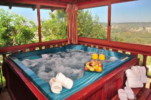 a jacuzzi tub with fruit and drinks in it at Spa Suites Bemorad Hahar in Even Menahem