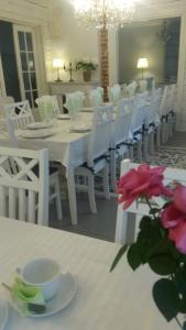 una sala da pranzo bianca con tavolo bianco e sedie bianche di Kyykerin Kartano a Outokumpu
