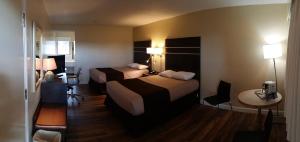 a hotel room with two beds and a table at Bear Country Inn in Terrace +22 photos