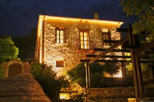 a stone building with lights on it at night at Ilakia in Tholón