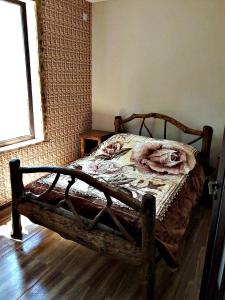 una camera da letto con un letto in legno e fiori di Arthur Rest House a Dilijan