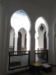 Cette chambre comprend 2 arches, une table et une fenêtre. dans l'établissement Riad Arous Chamel, à Tanger