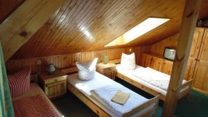 um quarto com 2 camas num chalé de madeira em Agrohotelik-gospodarstwo agroturystyczne em Mrągowo