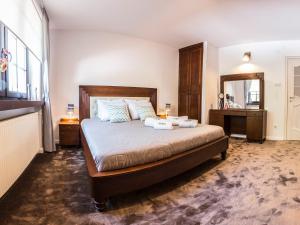 Un dormitorio con una cama grande y un espejo. en Ambre Apartments, en Łeba