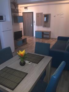 sala de estar con mesa y sillas azules en Sunset Apartment en Mamaia