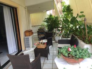 an outdoor patio with chairs and tables and plants at Filyra Homestay (Όμορφο δωμάτιο σε σπίτι) in Athens