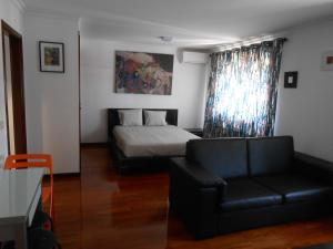 Sinos Rio Tinto في Campainha: غرفة معيشة مع سرير وأريكة
