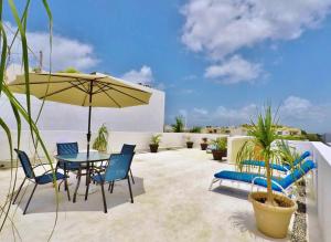 a patio with a table and chairs and an umbrella at Hotel El Campanario Playa del Carmen in Playa del Carmen
