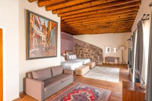 ein Wohnzimmer mit einem Bett und einer Couch in der Unterkunft Casa del Rector Hotel Boutique in Guanajuato