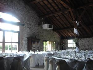 a room filled with tables with white table cloth at La Ferme aux Biches in Commelle-Vernay