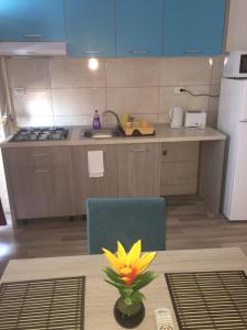 una cocina con una mesa y una flor amarilla en un jarrón en Sunset Apartment en Mamaia