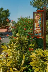 una señal junto a un arbusto con flores rojas en Nonna Vincenza en Maratea