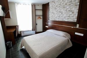 une chambre d'hôtel avec un lit et une fenêtre dans l'établissement Hotel des Pyrénées, à Paris