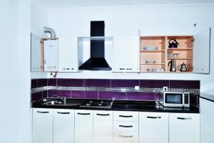a kitchen with white cabinets and purple counter tops at Appart Clim Wifi 700m de la Plage in Saïdia