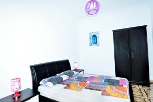 a bedroom with a bed with a quilt on it at Appart Clim Wifi 700m de la Plage in Saïdia