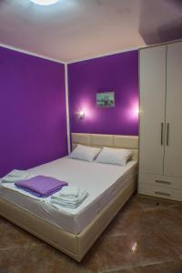 ein lila Schlafzimmer mit einem Bett und einer lila Wand in der Unterkunft Apartments Casa del Sol Jovana in Kotor