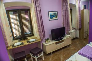 1 dormitorio con TV en un tocador y 1 cama en Apartments Casa del Sol Jovana en Kotor