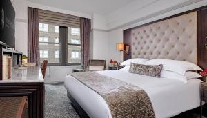 een slaapkamer met een groot wit bed en een raam bij WestHouse Hotel New York in New York