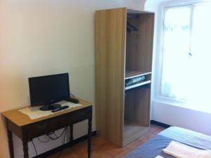 a room with a desk with a computer on it at Albergo Panson in Genova