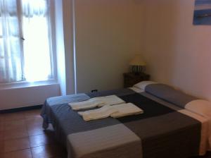 een slaapkamer met een bed met handdoeken erop bij Albergo Panson in Genua