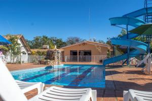 a swimming pool with a slide in a house at Pousada Sol Nascente in Paraopeba