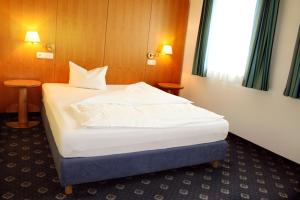 una camera da letto con un letto grande in una stanza di Hotel Servus Europa Suben a Suben