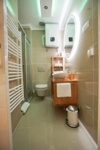 a bathroom with a sink and a toilet and a mirror at Destino City Apartments in Zadar
