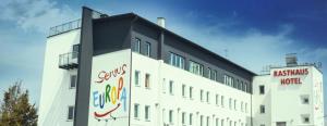 un gran edificio blanco con señales en el costado en Hotel Servus Europa Suben, en Suben