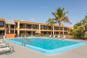 una piscina frente a un edificio con complejo en Travelodge by Wyndham Fort Myers North, en North Fort Myers
