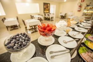 un buffet con un plato de fresas y arándanos sobre una mesa en Pousada Big Bear, en Campos do Jordão