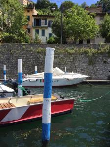 twee boten zijn aangemeerd in het water bij een muur bij Appartamento Terrazza sul Porto in Monte Isola