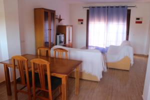 sala de estar con mesa y cama en Apartamentos Turísticos Edificio del Pino, en Sorbas
