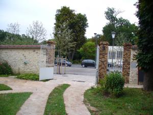 a gate to a driveway with a parking lot at Maison d'Hôtes Villa Brindille in Bois-le-Roi