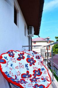 um guarda-chuva vermelho e branco sentado numa varanda em Casa Kmy em Tuzla
