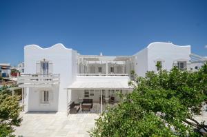 a white house with trees in front of it at Ostria Hotel in Agios Prokopios