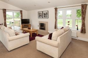 a living room with two couches and a tv at Augusta Dreams in Tydd Saint Giles