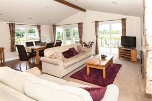 a living room with two couches and a tv at Augusta Dreams in Tydd Saint Giles