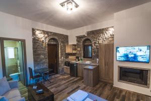a living room with a fireplace and a kitchen at Avgonima All Seasons Hotel in Avgonyma