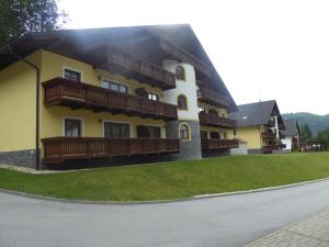 a large yellow building with wooden balconies on it at Apartman Tale in Tale