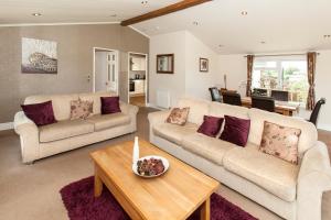 a living room with two couches and a table at Augusta Dreams in Tydd Saint Giles