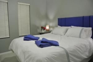 a large white bed with two blue towels on it at 28 and 29 The Bridge in St Lucia +61 photos