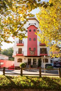 a pink and white building with trees in front of it at Pousada Big Bear in Campos do Jordão