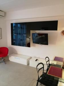 een woonkamer met een tv en een rode stoel bij Appartamento Betty in Porto Santo Stefano