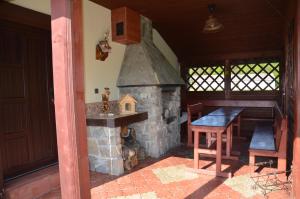eine Küche mit einem Steinkamin mit einem Tisch und einem Holztisch von sidx sidx sidx. in der Unterkunft Penzión pod Troma Korunami in Červený Kláštor