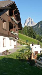 un edificio con fiori sui balconi con una montagna di Residence Prapoz a Ortisei