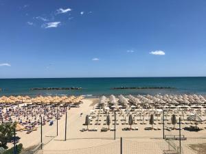 a beach with umbrellas and chairs and the ocean at Hotel La Bussola in Ortona
